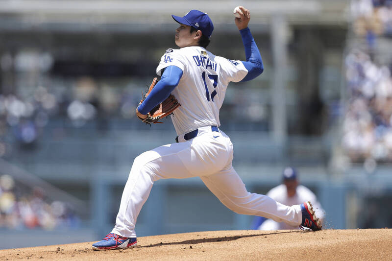 道奇球星大谷翔平身穿17號球衣，在主場投手丘上全力投球，展現流暢投球動作。