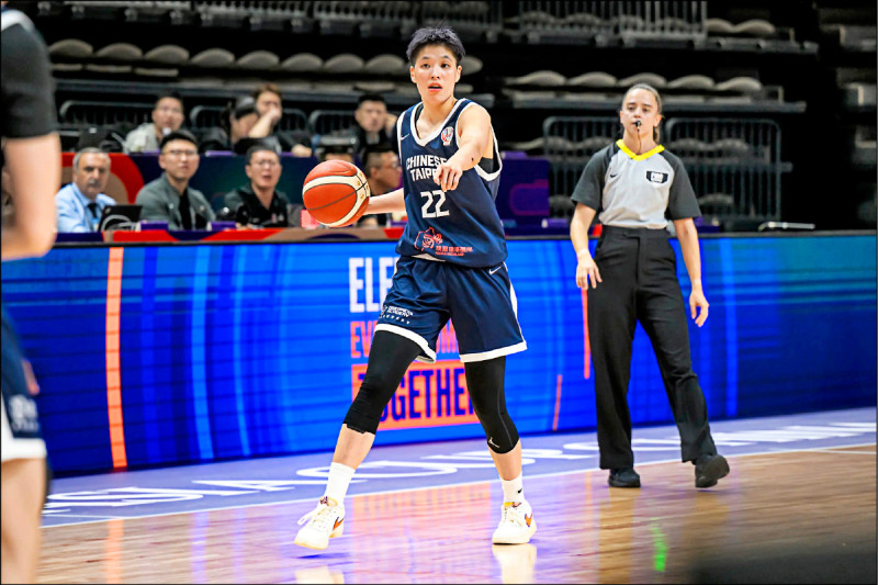 中華台北女籃球員林育庭在亞洲盃比賽中持球指揮戰術，身穿22號球衣，場邊裁判與觀眾注視比賽