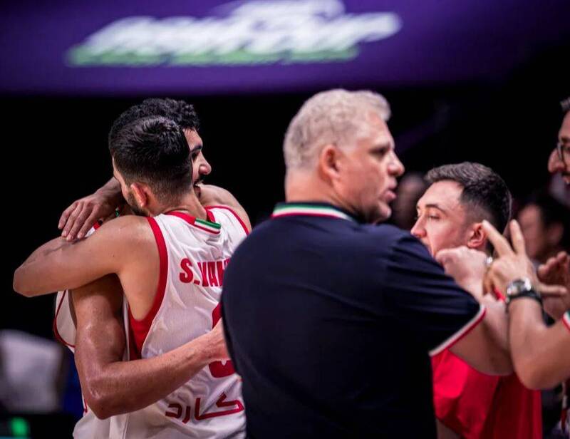 伊朗男籃主帥與球員在亞洲盃8強賽擊敗台灣後場邊擁抱慶祝，展現團隊凝聚力與喜悅神情。