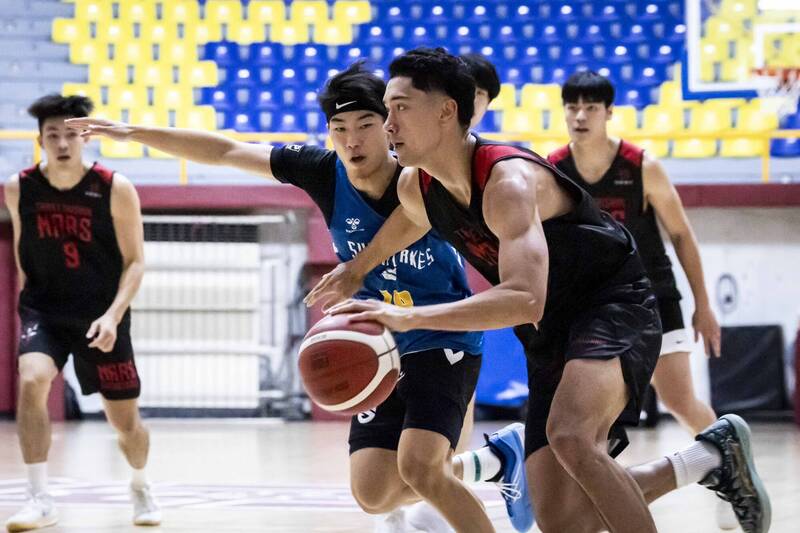 TPBL交流賽中，台新戰神雷蒙恩持球強攻，游艾喆嚴防對位，場上激烈對抗畫面