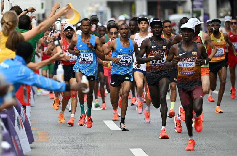 在日本東京舉行的2025年世界田徑錦標賽男子馬拉松比賽中，多名選手在賽道上齊頭並進，包括來自坦尚尼亞和烏干達的選手，場面激烈壯觀。