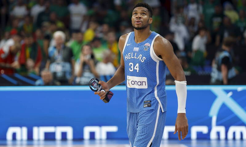 希臘球星字母哥亞德托昆波在歐錦賽擊敗立陶宛後，手持獎盃走向場邊，展現領袖風範。