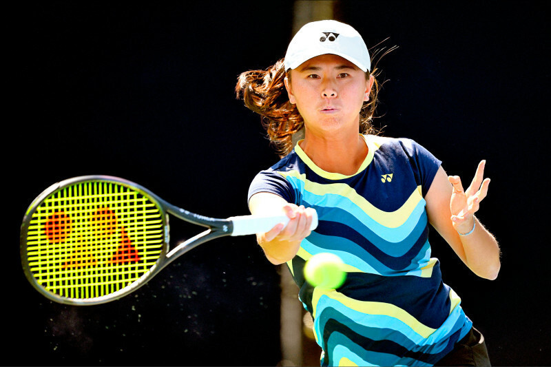 台灣網球選手吳芳嫺在美網女雙比賽中專注揮拍擊球，展現全力拚戰的氣勢。