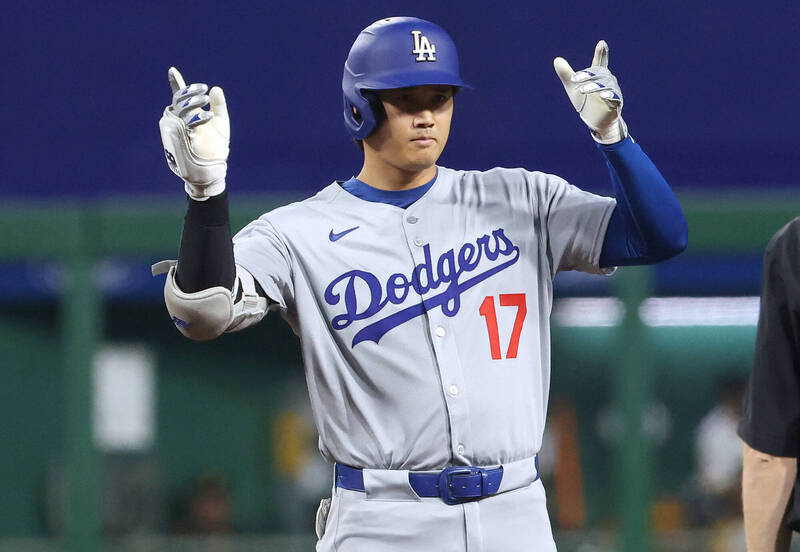 道奇隊大谷翔平在比賽中敲出安打後，站上壘包比出手勢慶祝，展現奮戰精神。