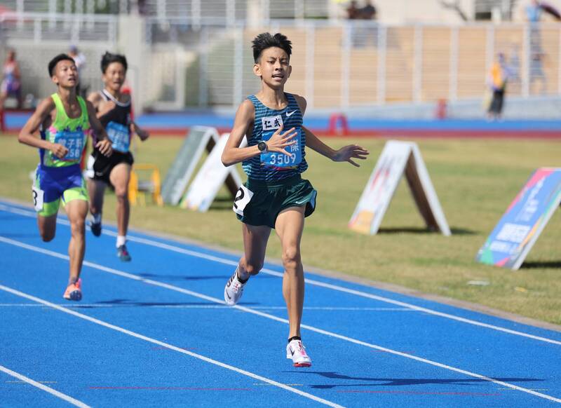 田徑選手在藍色跑道全力衝刺，呈現簡子傑突破5000公尺全國紀錄時的長跑氣勢。