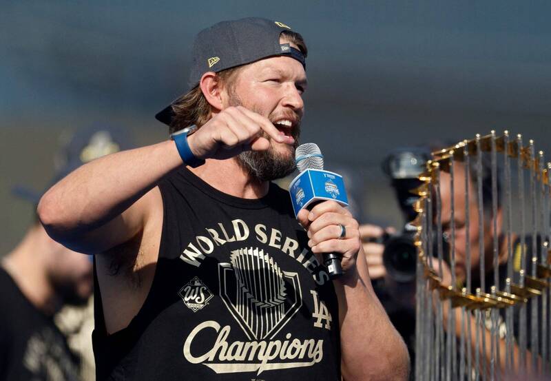 克蕭在道奇奪冠慶典上手持麥克風發表談話，身旁可見世界大賽冠軍獎盃