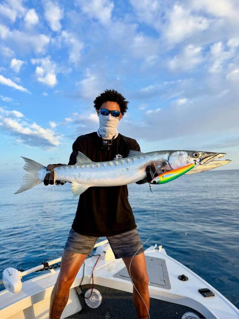 西蒙斯站在釣魚船上手持大型旗魚，展現轉戰職業釣魚領域的全新身分