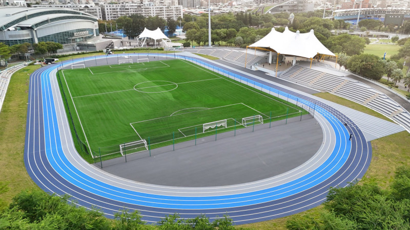 新北市新莊田徑場整修後全景，藍灰三色分道跑道環繞足球場，場地整齊明亮