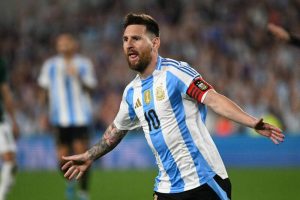 阿根廷足球國家隊傳奇隊長梅西（Lionel Messi）身穿藍白條球衣在場上振臂歡呼。他正式入選 2026 年世界盃 26 人大名單，生涯第六度參戰世界盃寫下歷史。