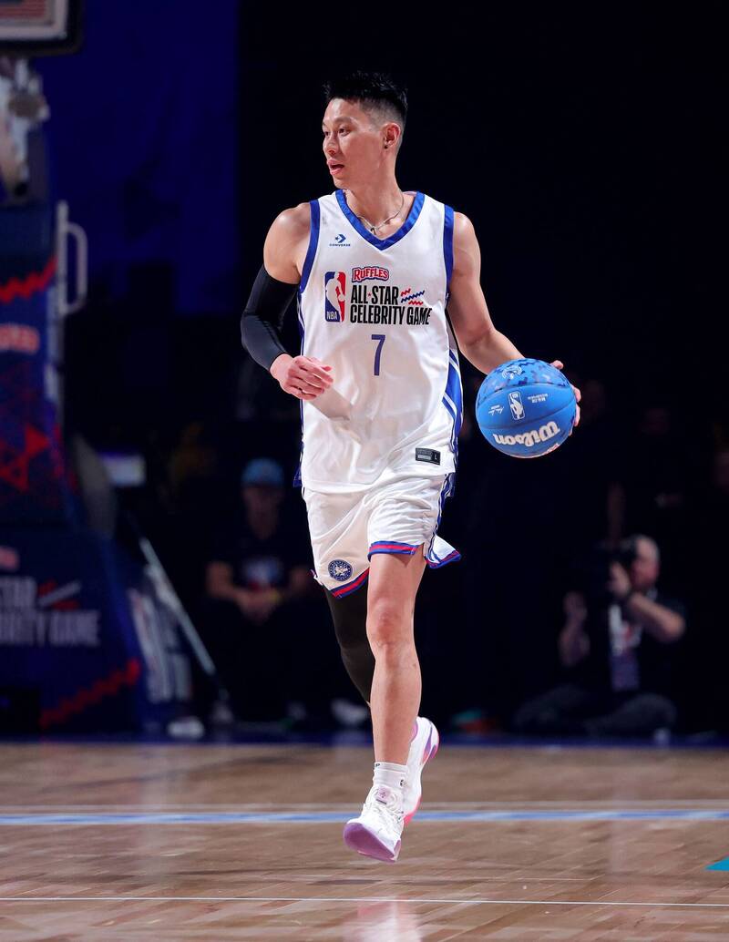 華裔籃球名將林書豪身穿白底藍邊、胸前印有「NBA ALL-STAR CELEBRITY GAME」與背號7號的正式比賽球衣，左手持著一顆藍色威爾森（Wilson）品牌籃球，在木地板球場上專注地運球前進。