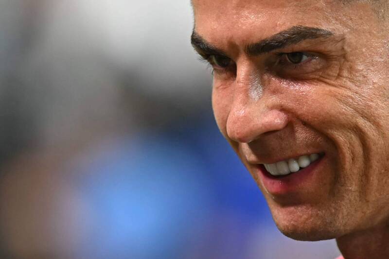 葡萄牙傳奇球星C羅（Cristiano Ronaldo）的臉部特寫。他展現出帶有自信的燦爛笑容，露出一整排潔白的牙齒。畫面聚焦在他專注且深邃的眼神、濃密的眉毛以及在球場燈光照射下微微流汗的皮膚紋理。