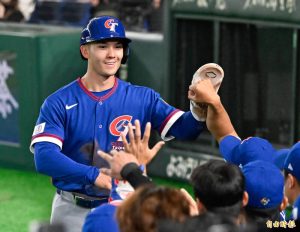 身穿中華隊藍色客場「Chinese Taipei」球衣的費爾柴德，頭戴藍色打擊頭盔，面帶燦爛笑容回到休息區，與擊掌的隊友們高舉左手進行大力擊掌慶祝。