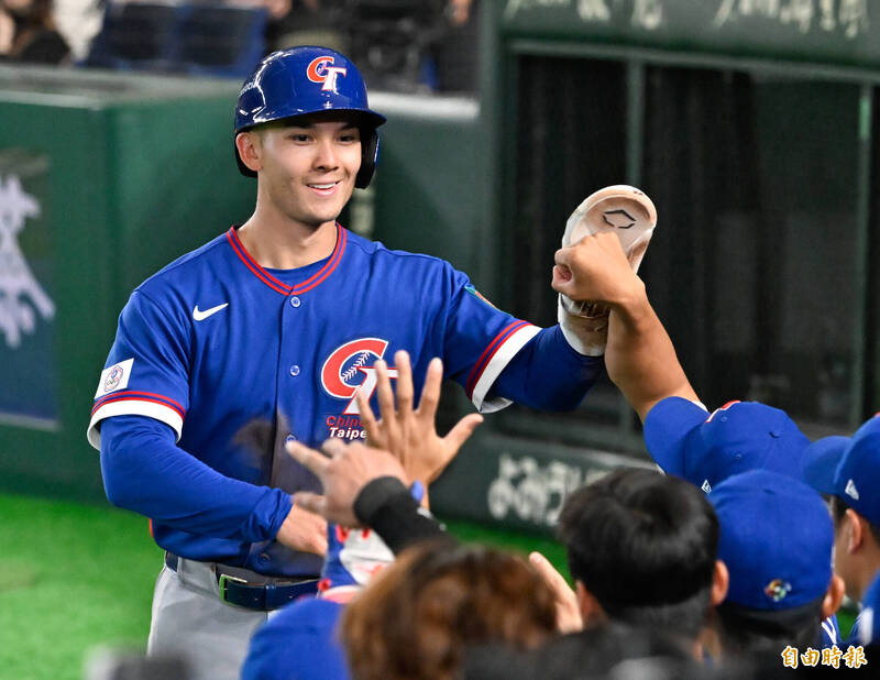 身穿中華隊藍色客場「Chinese Taipei」球衣的費爾柴德，頭戴藍色打擊頭盔，面帶燦爛笑容回到休息區，與擊掌的隊友們高舉左手進行大力擊掌慶祝。