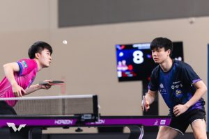 台灣桌球選手林昀儒(左)身穿粉色球衣專注盯著空中彈起的乒乓球,馮翊新(右)身穿深藍色球衣雙手握拍嚴陣以待。