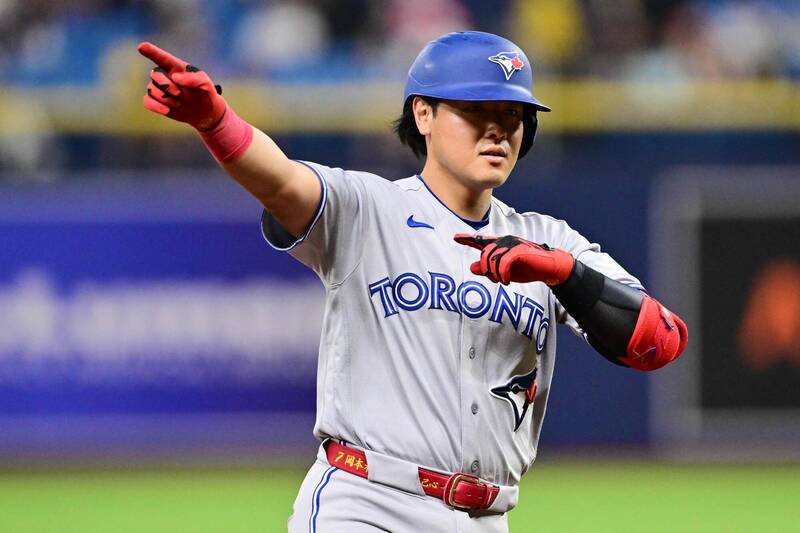 岡本和真身穿藍 烏隊灰色客場球衣在球場上比出慶祝手勢。