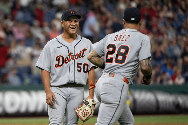 李灝宇身穿老虎隊灰色客場球衣在賽場上與隊友巴耶茲（Javier Báez）開心微笑互動。