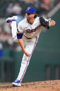 德葛隆身穿遊騎兵隊白色主場球衣在投手丘上高舉左腳邁步投球。