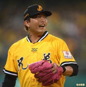 林克謙身穿中信兄弟黃色主場球衣在球場上露齒微笑準備投球。