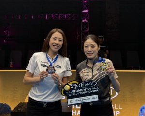台灣撞球選手魏子茜與周婕妤身穿賽服展示獎牌，周婕妤手持世錦賽冠軍獎座微笑合影。