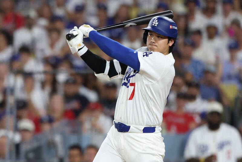 洛杉磯道奇隊球員大谷翔平身穿白色主場球衣、戴藍色打擊頭盔，在打擊區上揮棒打擊。